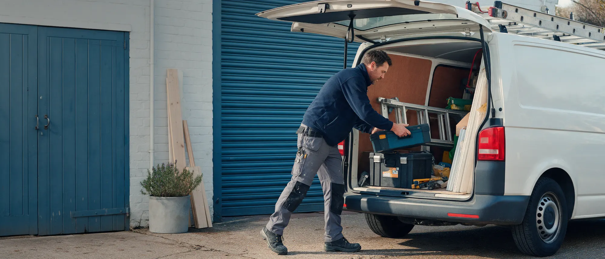 Handwerker belädt seinen Transporter mit Werkzeug und Material